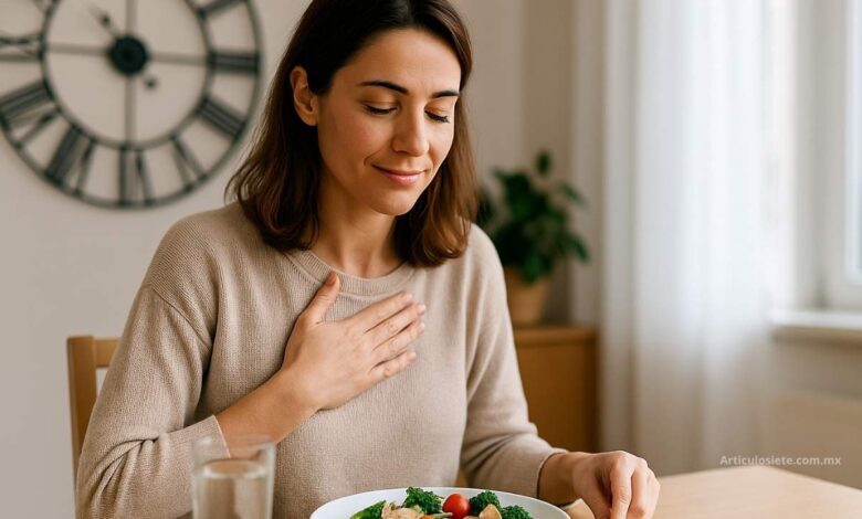 Mujer sentada en su cocina tomando agua durante el ayuno intermitente, con actitud tranquila y saludable